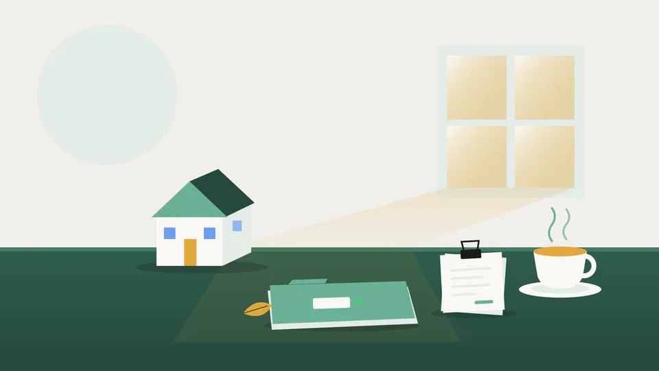 Een opgeruimd bureau in herfstlicht met een klein modelhuisje, een samengeklemde stapel bonnetjes, een gesloten map en een kop thee.